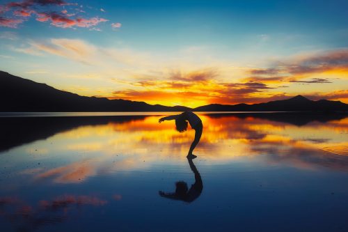 A picture of the sunset and a person doing yoga